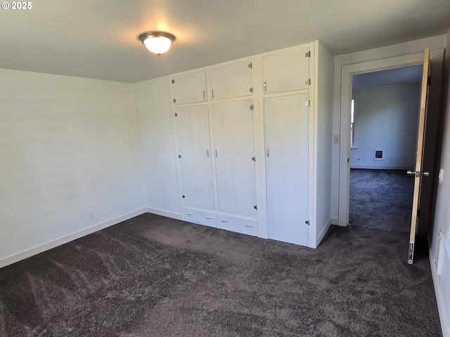 3208 W 7th St, The Dalles, OR 97058 - unfurnished bedroom featuring dark carpet, baseboards, and a closet