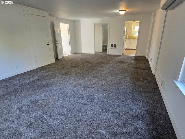 3208 W 7th St, The Dalles, OR 97058 - unfurnished room with dark colored carpet, an AC wall unit, and baseboards