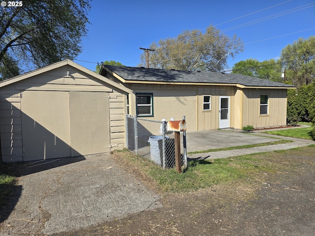3208 W 7th St, The Dalles, OR 97058 - exterior space with a shingled roof, a storage shed, concrete block siding, fence, and an outdoor structure