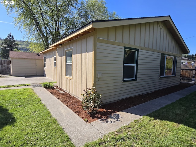 3208 W 7th St, The Dalles, OR 97058 - view of side of property featuring board and batten siding, fence, and a lawn
