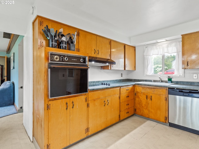kitchen featuring stainless steel dishwasher, black oven, light floors, under cabinet range hood, and a sink