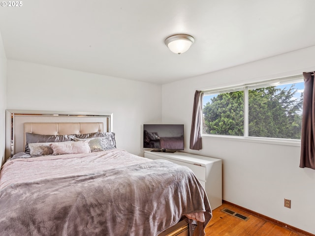 bedroom with visible vents, light wood-style flooring, and baseboards