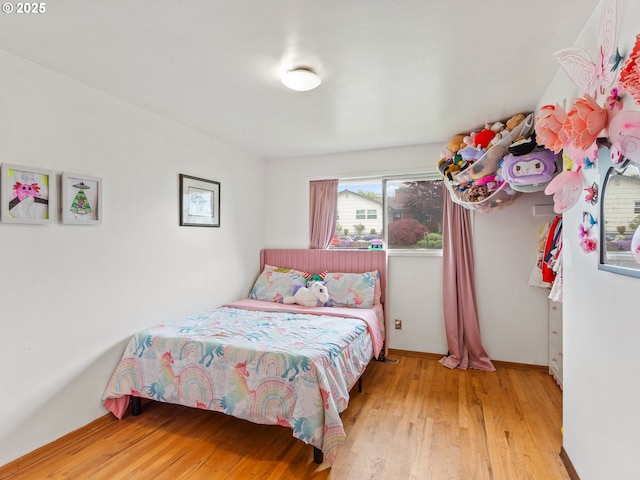 bedroom featuring baseboards and wood finished floors