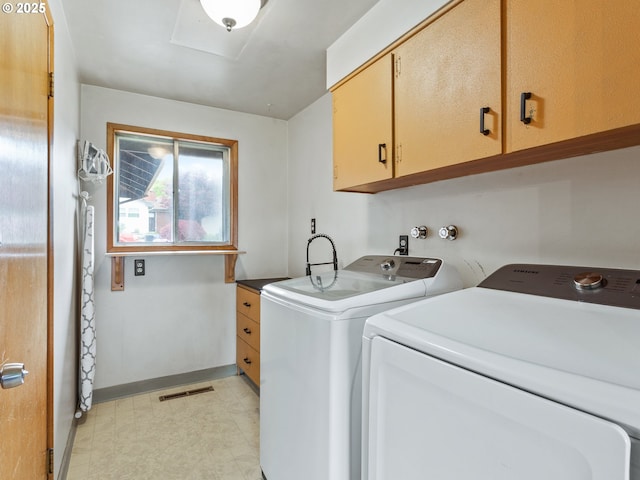 washroom featuring cabinet space, separate washer and dryer, baseboards, and light floors