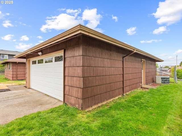 view of home's exterior with a garage, a yard, an outbuilding, and concrete driveway