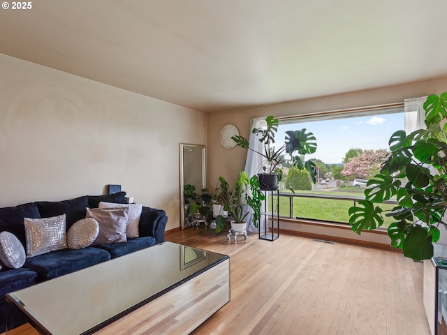 living area with wood finished floors and visible vents