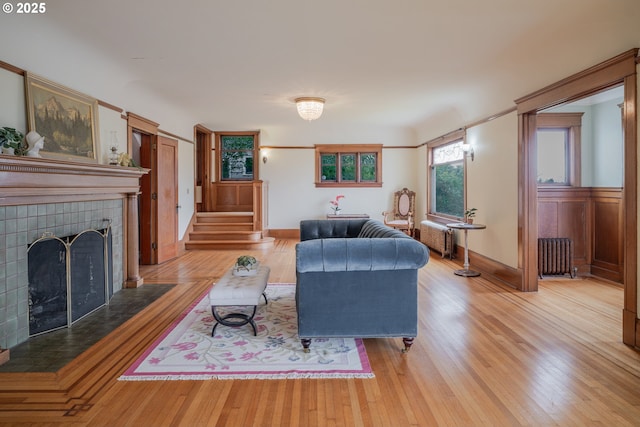 1343 Jerome Ave, Astoria, OR 97103 - living area with radiator heating unit, stairs, a fireplace, and light wood-style floors