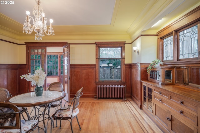 1343 Jerome Ave, Astoria, OR 97103 - dining room with radiator, a wainscoted wall, healthy amount of natural light, a chandelier, and light wood-style floors