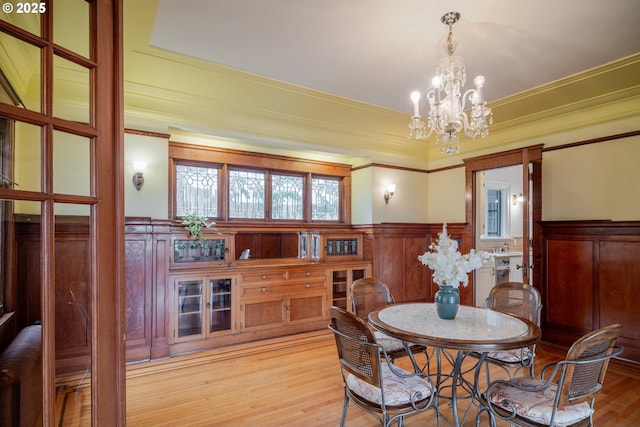 1343 Jerome Ave, Astoria, OR 97103 - dining room with a chandelier, a wainscoted wall, light wood-type flooring, and crown molding