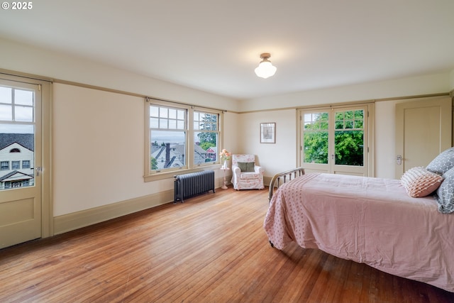 1343 Jerome Ave, Astoria, OR 97103 - bedroom with radiator heating unit, wood finished floors, and multiple windows