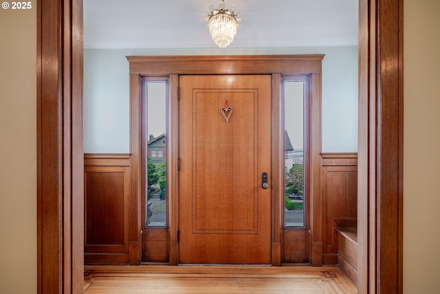 1343 Jerome Ave, Astoria, OR 97103 - foyer featuring a chandelier, healthy amount of natural light, light wood finished floors, and a wainscoted wall