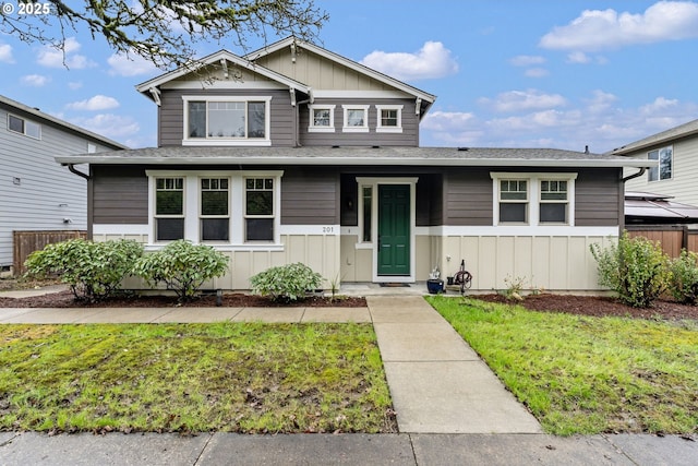 view of front facade with board and batten siding and a front yard