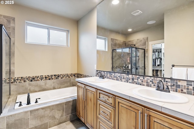 full bath featuring a shower stall, a garden tub, visible vents, and a sink