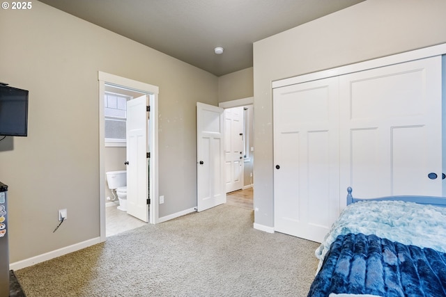 bedroom featuring ensuite bath, carpet flooring, baseboards, and a closet