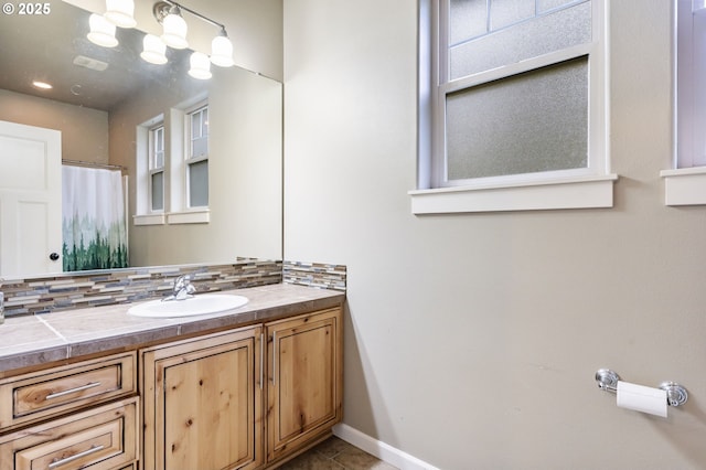 full bath with tile patterned floors, curtained shower, backsplash, baseboards, and vanity