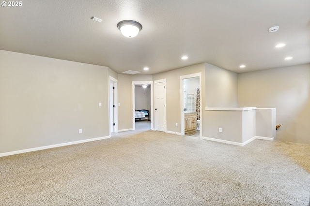 carpeted empty room featuring recessed lighting, visible vents, baseboards, and a textured ceiling