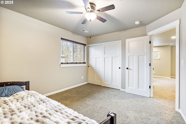 carpeted bedroom featuring visible vents, baseboards, a closet, and ceiling fan