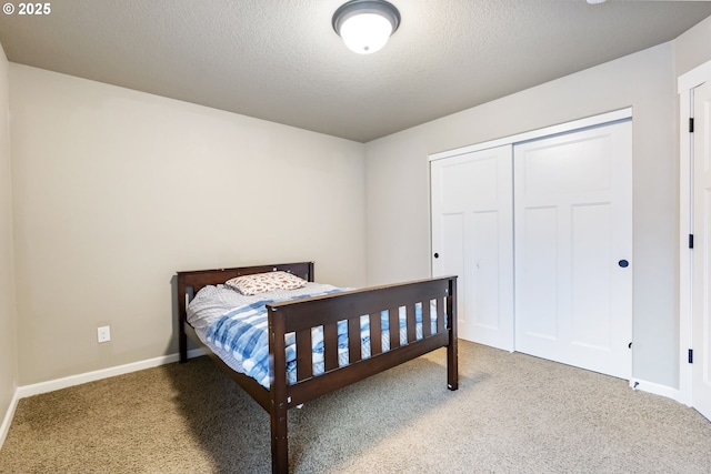 carpeted bedroom featuring baseboards, a closet, and a textured ceiling