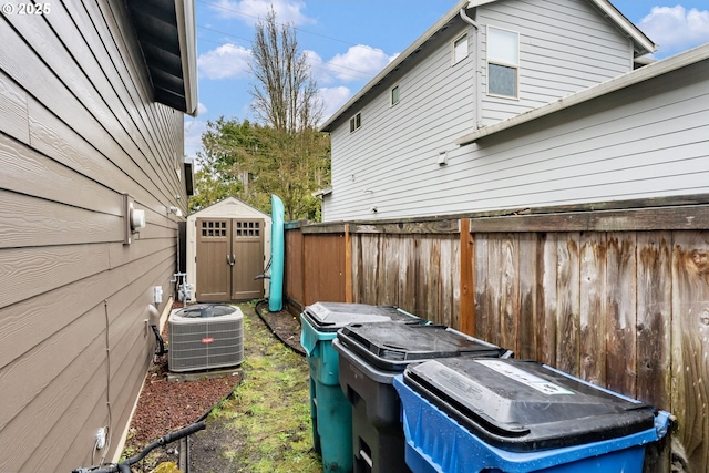 view of yard with a storage shed, cooling unit, fence, and an outdoor structure