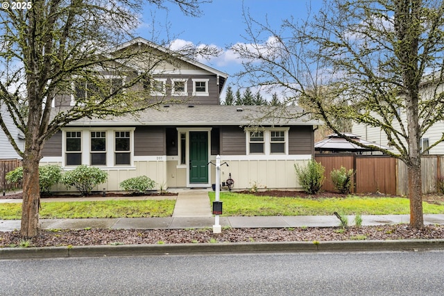 view of front of home with board and batten siding and fence