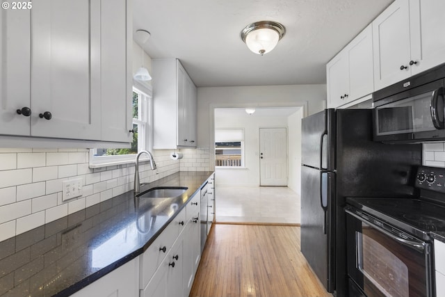 2000 Harney St, Vancouver, WA 98660 - kitchen featuring black appliances, white cabinetry, light wood-style flooring, dark stone countertops, and tasteful backsplash