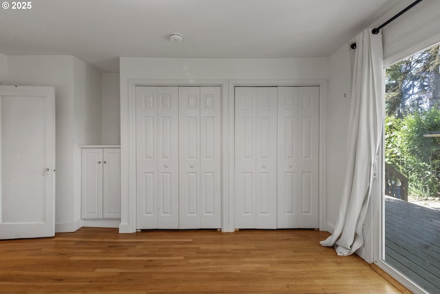 2000 Harney St, Vancouver, WA 98660 - unfurnished bedroom featuring multiple closets, access to exterior, and light wood-style flooring