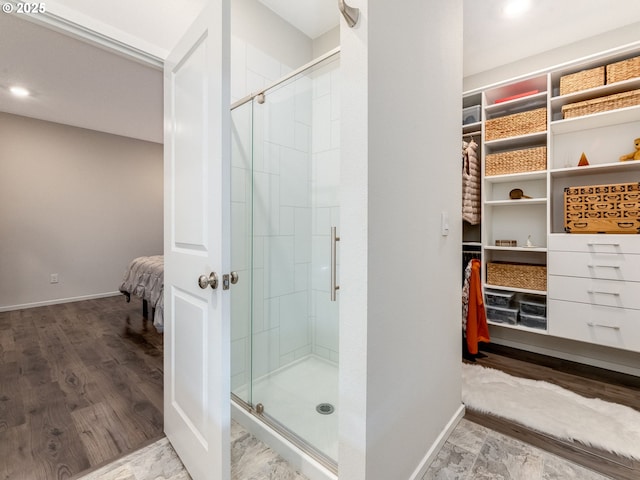 bathroom with walk in shower and hardwood / wood-style floors