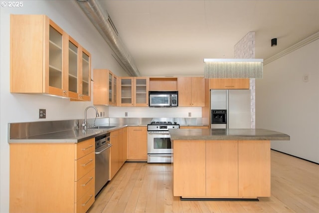 kitchen featuring appliances with stainless steel finishes, light brown cabinetry, sink, stainless steel counters, and a center island