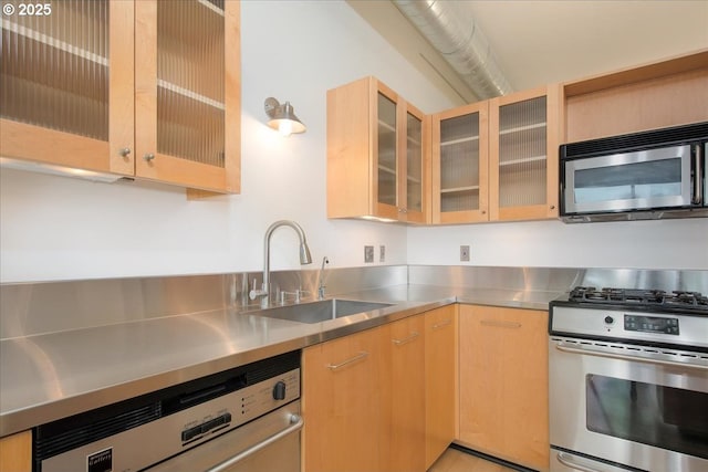 kitchen featuring appliances with stainless steel finishes, light brown cabinetry, sink, and stainless steel counters