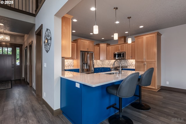 34800 Westboro Way, Saint Helens, OR 97051 - kitchen with appliances with stainless steel finishes, a sink, dark wood-style flooring, a peninsula, and backsplash