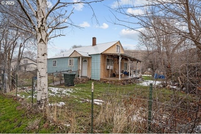 rear view of house featuring a porch