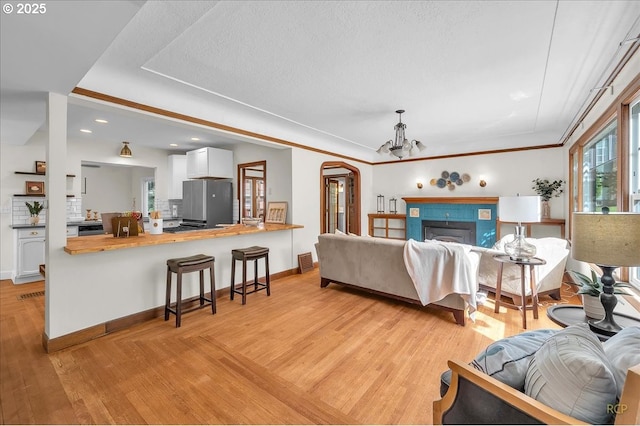 3700 NE Maywood Pl, Portland, OR 97220 - living area featuring light wood-style floors, a chandelier, baseboards, recessed lighting, and arched walkways