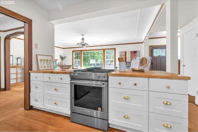 3700 NE Maywood Pl, Portland, OR 97220 - kitchen with butcher block counters, electric stove, white cabinets, crown molding, and a chandelier