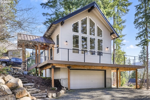 view of home's exterior with stairs, metal roof, and an attached garage