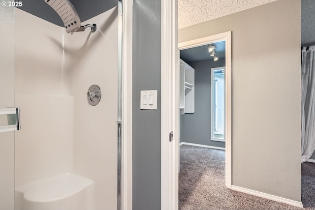 bathroom featuring a shower and a textured ceiling