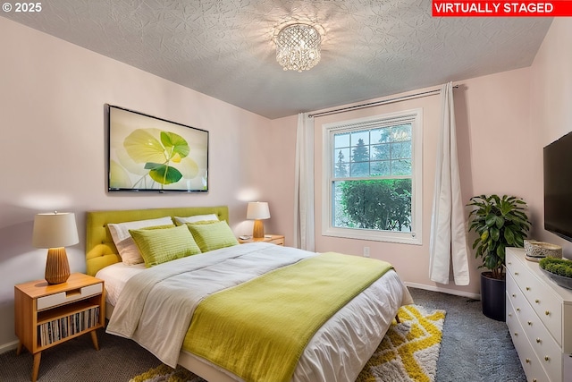 bedroom featuring a textured ceiling, a chandelier, and dark carpet