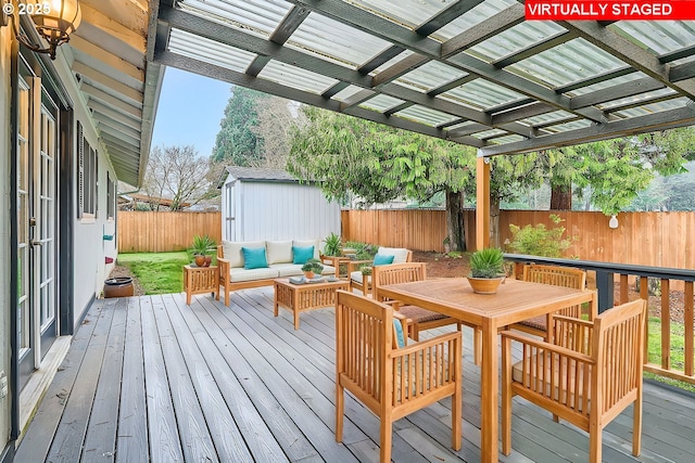 wooden deck featuring an outdoor living space, a shed, and a pergola