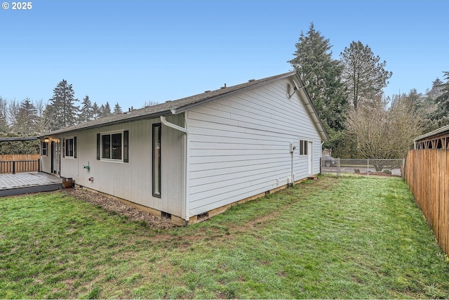 view of side of property featuring a deck and a lawn