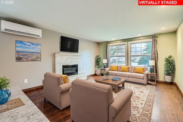 living room featuring a brick fireplace, dark hardwood / wood-style floors, and an AC wall unit