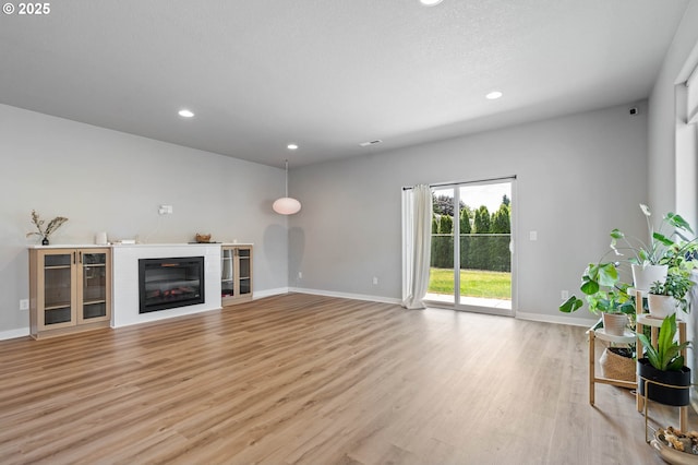 5807 NE 77th Cir, Vancouver, WA 98661 - unfurnished living room featuring light wood-type flooring, recessed lighting, and a glass covered fireplace