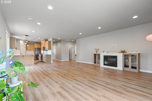 5807 NE 77th Cir, Vancouver, WA 98661 - unfurnished living room with recessed lighting, light wood-style flooring, and a glass covered fireplace