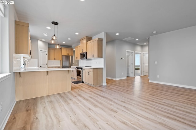 5807 NE 77th Cir, Vancouver, WA 98661 - kitchen with appliances with stainless steel finishes, light brown cabinetry, a peninsula, light wood-type flooring, and light countertops