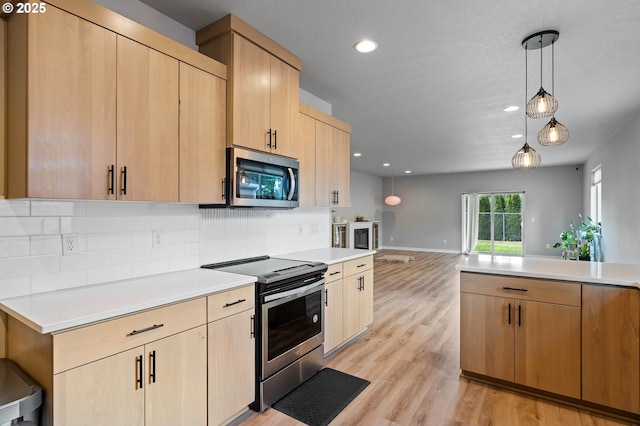 5807 NE 77th Cir, Vancouver, WA 98661 - kitchen featuring stainless steel appliances, light countertops, tasteful backsplash, decorative light fixtures, and recessed lighting