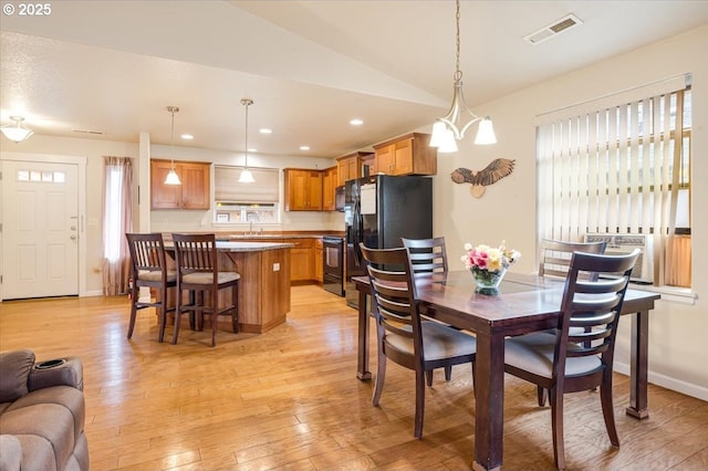 dining room featuring vaulted ceiling, light wood-style flooring, visible vents, and recessed lighting