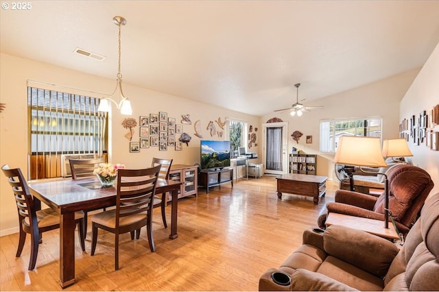 dining room with lofted ceiling, ceiling fan, light wood-type flooring, and visible vents