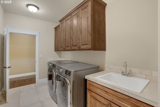 4506 NE 121st St, Vancouver, WA 98686 - washroom featuring independent washer and dryer, cabinet space, a textured ceiling, light tile patterned floors, and baseboards
