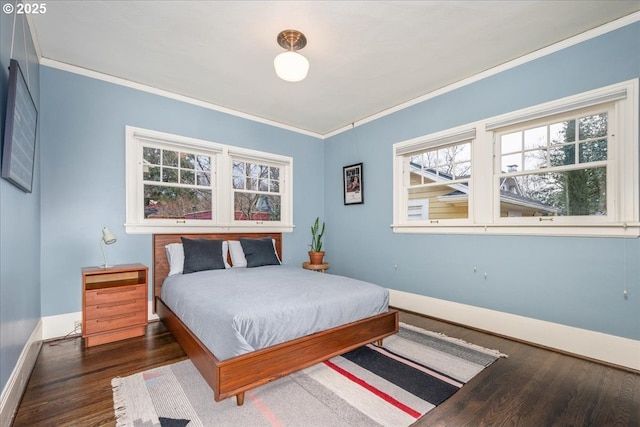 bedroom with wood finished floors, baseboards, and ornamental molding