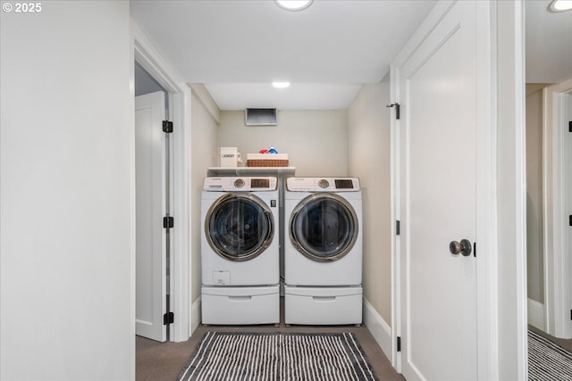 clothes washing area with baseboards, carpet, washing machine and dryer, and laundry area