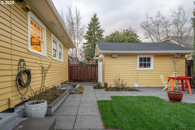 exterior space with a patio, a garden, fence, and an outdoor fire pit