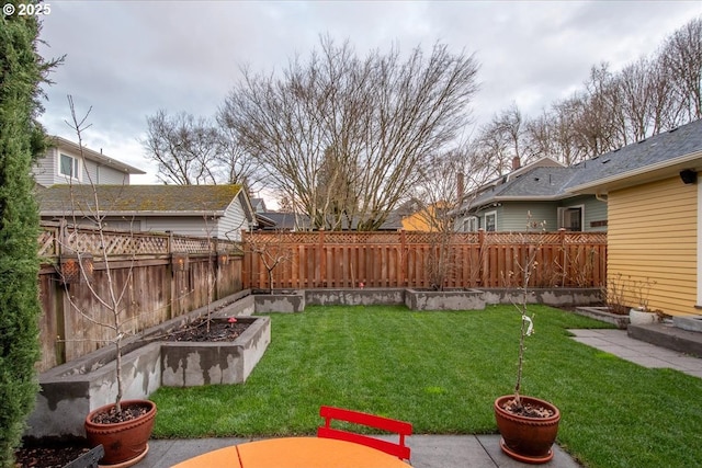 view of yard featuring a garden and a fenced backyard